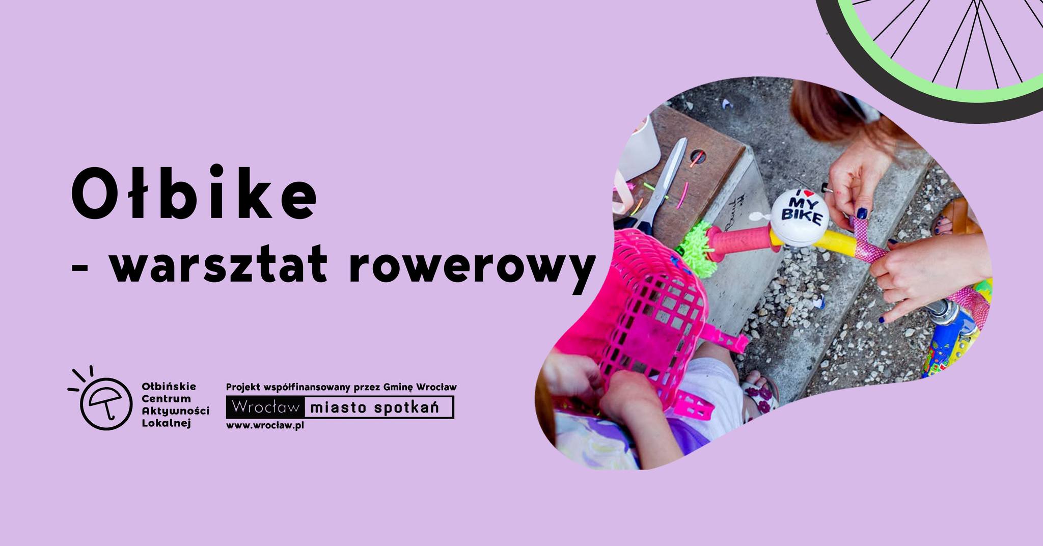 obraz na fioletowym tle znajduje się tekst informujący o wydarzeniu: "Ołbike - warsztat rowerowy, sobota 17.05, godz. 16.30". W lewym dolnym rogu znajduje się logo Ołbińskiego Centrum Aktywności Lokalnej oraz informacja, że projekt jest współfinansowany przez Gminę Wrocław. W prawym dolnym rogu jest zdjęcie przedstawiające osobę ozdabiającą rower, na którym widoczny jest dzwonek z napisem "I love my bike". W prawym górnym rogu widać fragment koła rowerowego