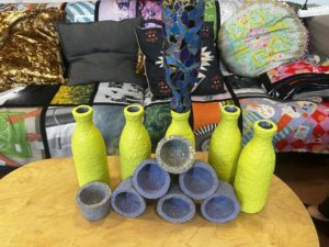 obraz stół i kanapa a na niej kolorowe wazony