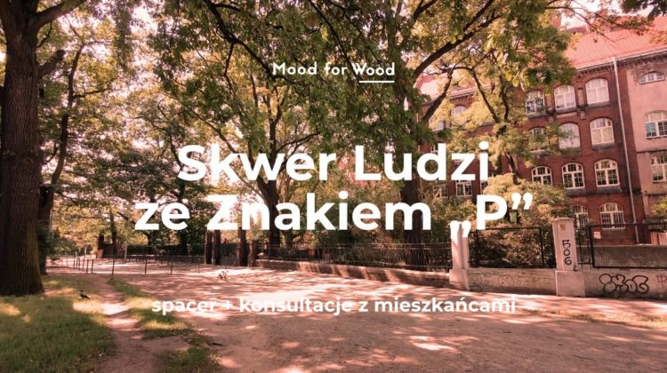Parkowy skwer z dużymi drzewami przy ulicy, z tyłu widać ceglasty budynek z wieloma oknami. Tekst na środku zdjęcia: Mood for Wood Skwer Ludzi ze Znakiem „P” Na dole napis: spacer + konsultacje z mieszkańcami